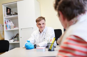 Doctor is listening to a patient, smiling